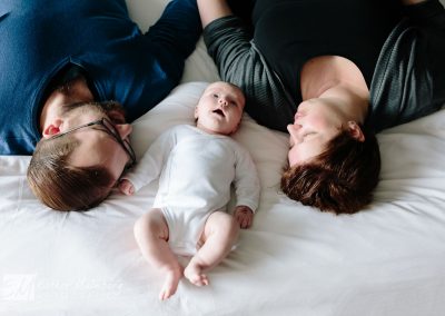 Het bed in de ouderslaapkamer is perfect voor een familiefoto tijdens een baby lifestyle reportage