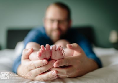 Baby voetjes in de handen van de trotse vader: wat een contrast